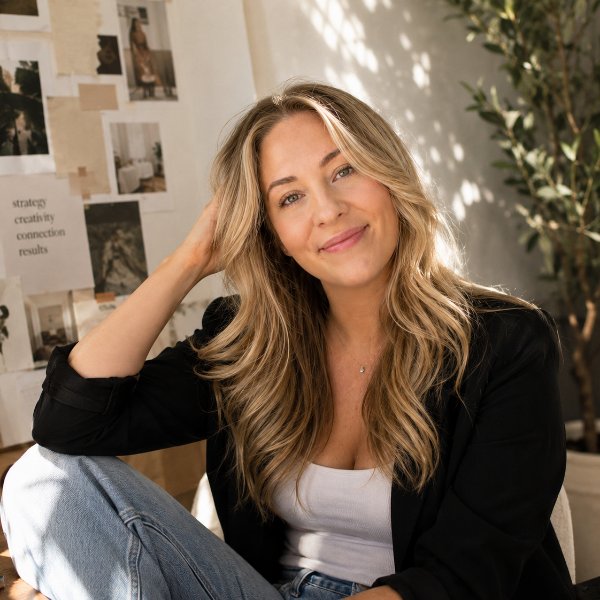 Amber Fugedi, marketing consultant in Connecticut, seated in a sunlit studio in front of a wall of pinned reference images.